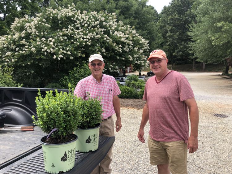 Bennett en Robert Saunders staan bij een wagen op het terrein van het familiebedrijf Saunders Brothers in Amerika Bennett en Robert Saunders staan bij een wagen op het terrein van het familiebedrijf Saunders Brothers in Amerika