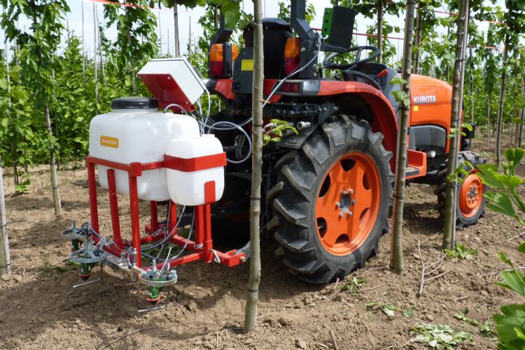 Driepuntgedragen LvS-gps-strooier in de laanbomen Driepuntgedragen LvS-gps-strooier in de laanbomen